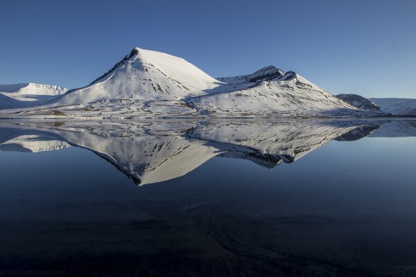 Reflexion der schneebedeckten Berge im See
