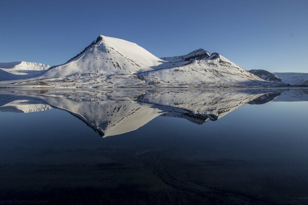 Reflejo de las montañas nevadas en el lago