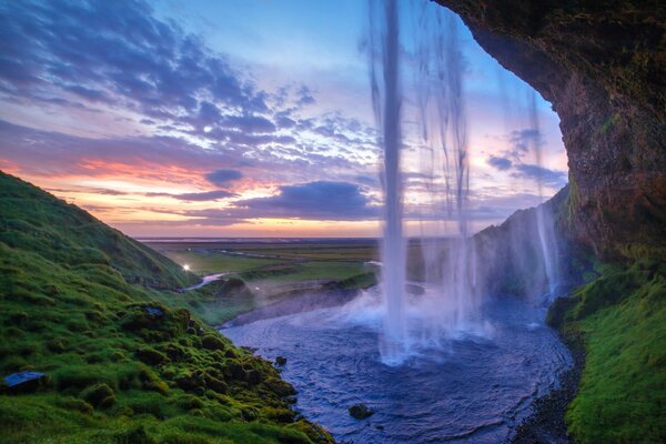 Wasserfall von einem Felsen bei Sonnenuntergang