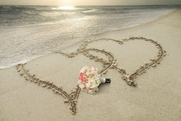 Два сердца, нарисованные на песчаном пляже