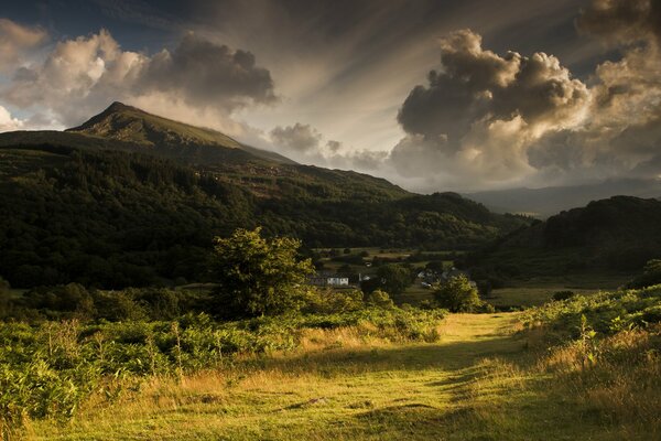 Mountain valley with voluminous clouds