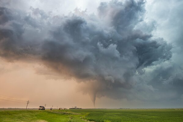 Der Tornado bewegt sich. Gewitterhimmel. Menschen und Autos unterwegs