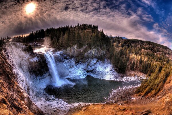 Waterfall. Forest and mountains. The clouds