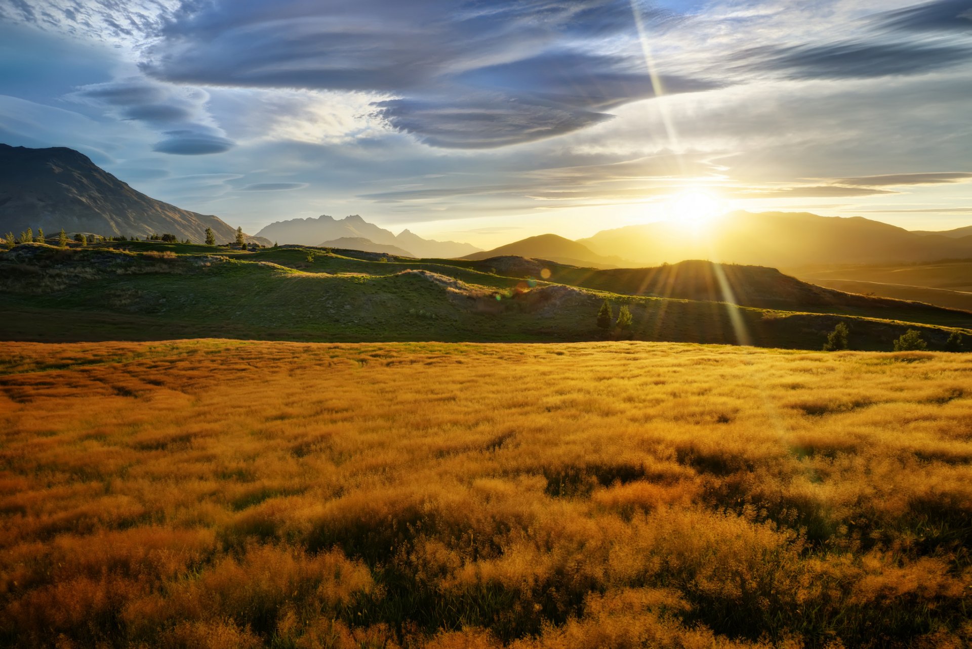 nouvelle-zélande montagnes collines champ herbe soleil rayons éblouissement nuages