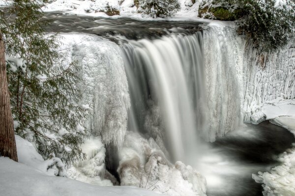 Waterfall in the senezhny forest in winter