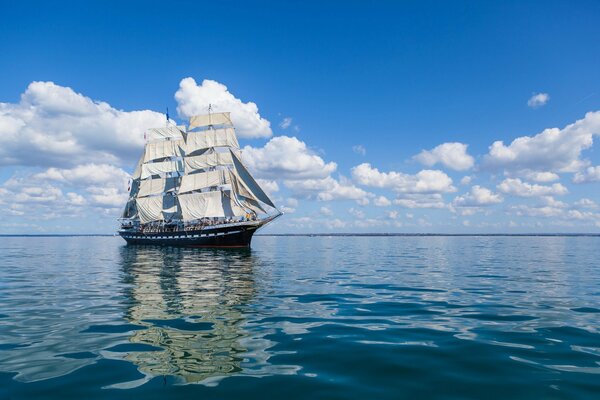 Navire avec des voiles blanches dans la mer