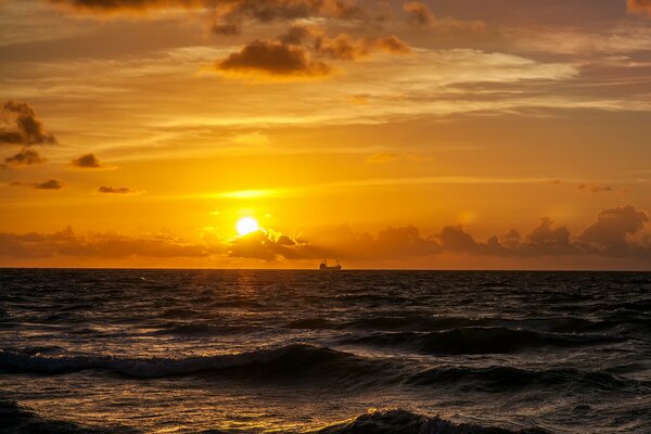 A beautiful sunrise is visible on the sea