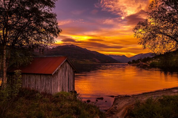 Casa en un lago al atardecer en Noruega