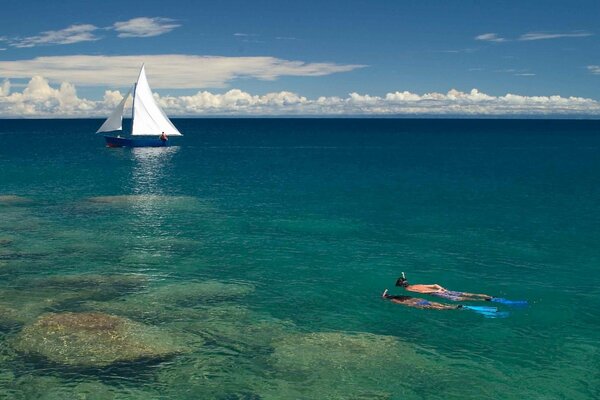 Pareja navegando bajo el agua hasta el barco