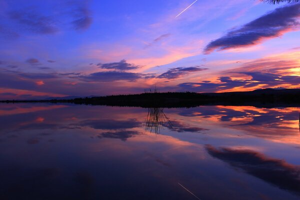 Por la noche, la puesta de sol se refleja en el lago