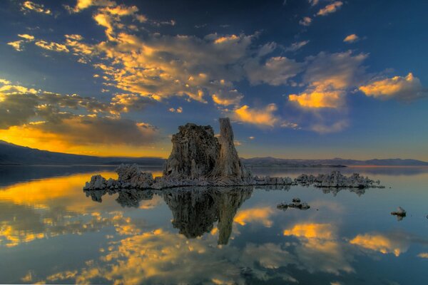 Rocks protrude from the water and are reflected in it