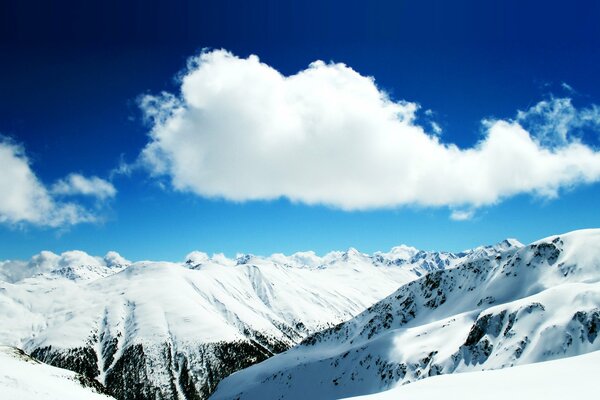 White cloud over the peaks of snowy mountains