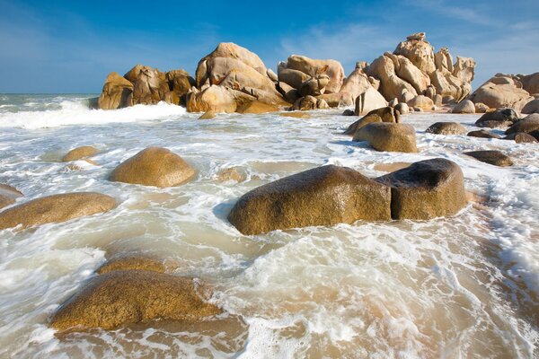 Les vagues de la mer se brisent sur les rochers sur le rivage