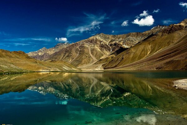 Riflessione di montagne e nuvole nel lago