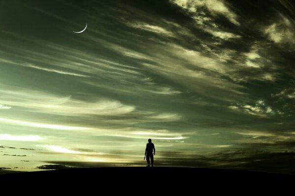 A man against the background of the night sky, on which clouds float