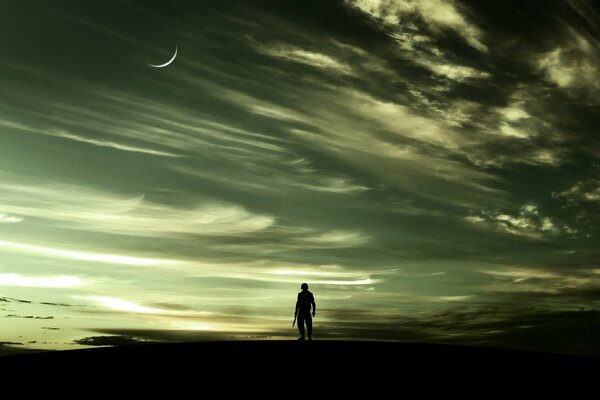 Человек на фоне ночного неба, по которому плывут облака