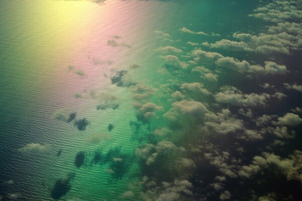 В океане отображены радуга и облака