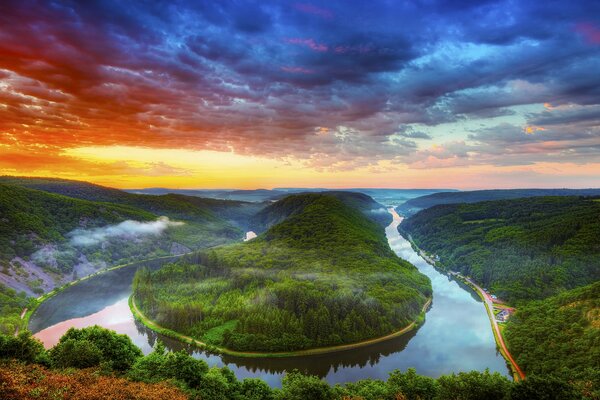 Ciel multicolore au-dessus de la forêt et de la rivière