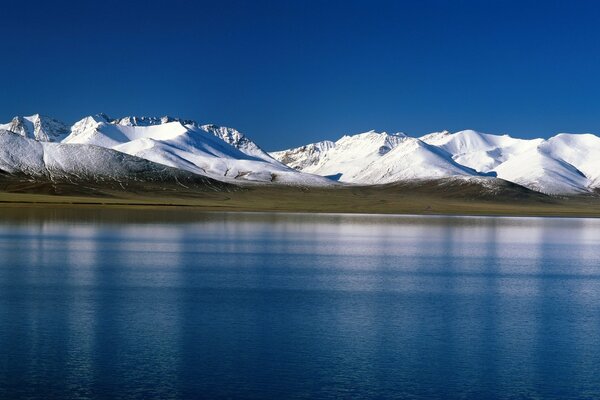 Lac bleu sur fond de montagnes enneigées