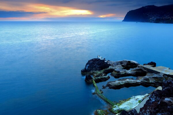 Île de roches sur la mer au coucher du soleil