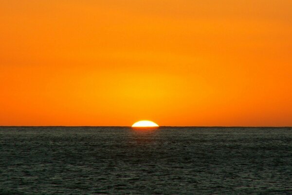 Pomarańczowy zachód słońca, linia horyzontu morza i nieba