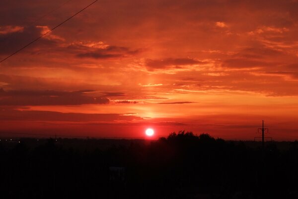 Puesta de sol roja y naranja sobre una pequeña ciudad