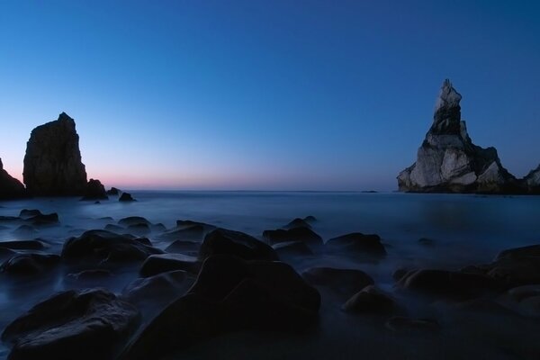 Puesta de sol en el mar entre las rocas