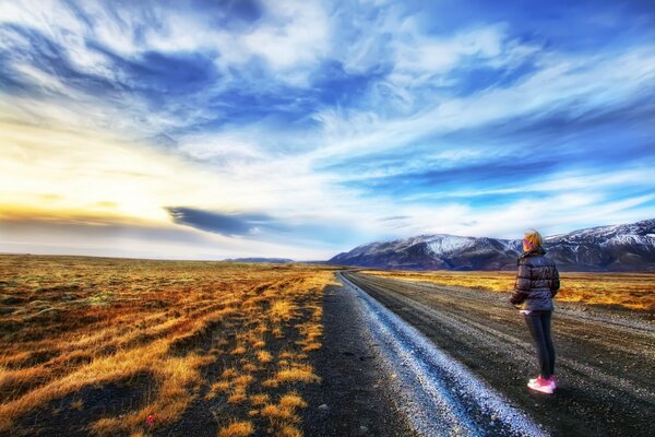 La jeune fille se dirige vers les montagnes sur un terrain plat