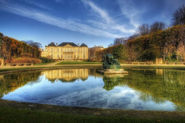 A beautiful mansion is reflected in the fountain