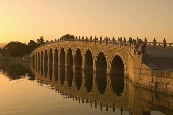 Architektonische Brücke über den Fluss bei Sonnenuntergang