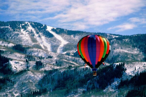 Heißluftballon für Flüge vor dem Hintergrund der schneebedeckten Berge