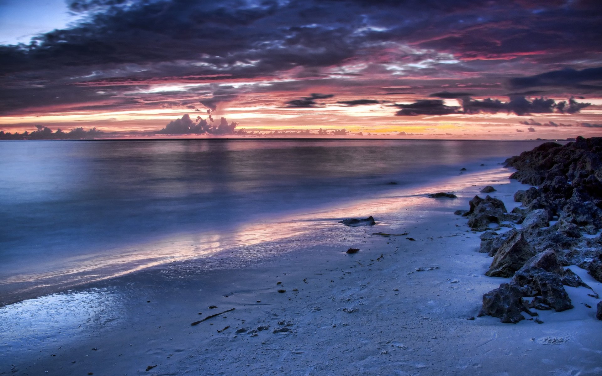 côte coucher de soleil nuages pierres mer