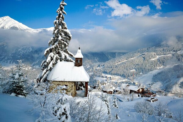 Kleines Haus in den schneebedeckten Bergen