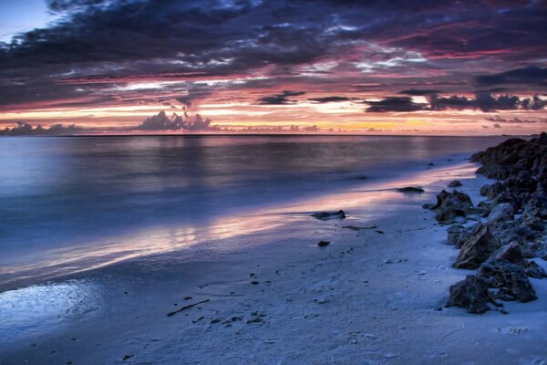 Am Meer gibt es Steine. Sonnenuntergang und Wolken