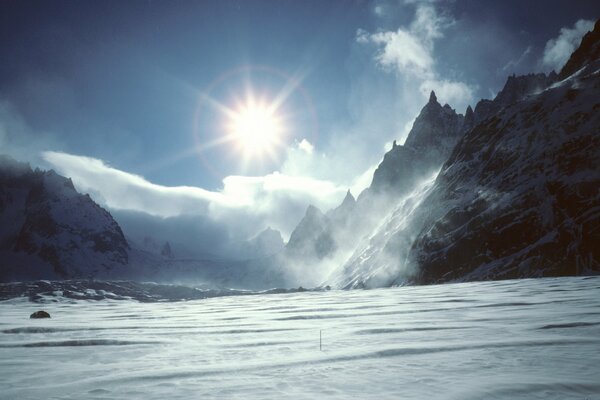 White snow and bright sun on the background of mountain peaks