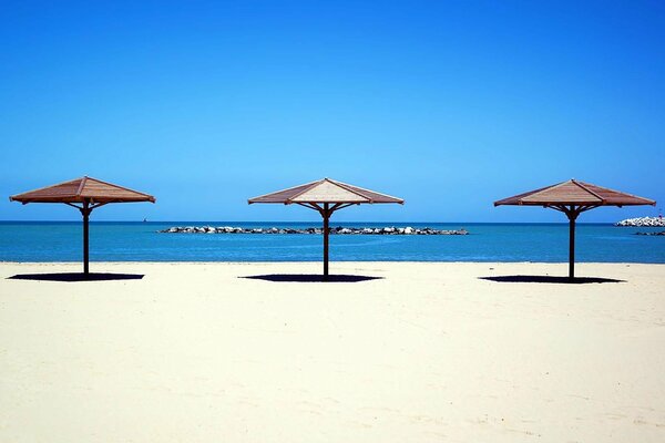 Beach umbrellas by the sea on white sand