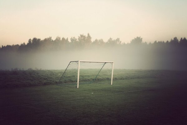 A sports ground with a football goal in the fog