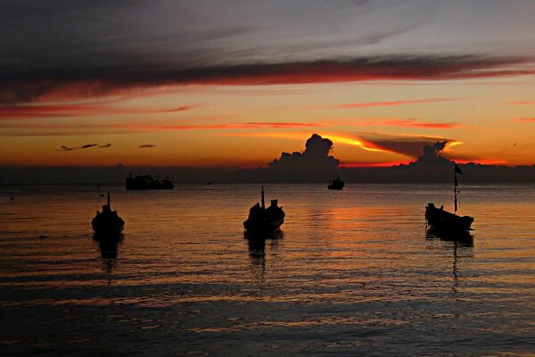 Boote kehren bei Sonnenuntergang nach Hause zurück