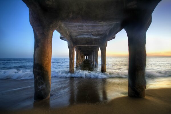 Muelle. Puesta de sol EA orilla del mar