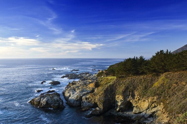 The rocky seashore of California. The blue of the sky