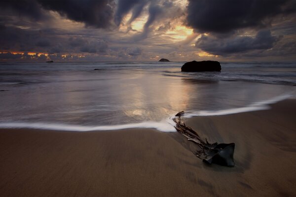 Foto eines Strandes in Neuseeland vor dem Hintergrund des Sonnenuntergangs