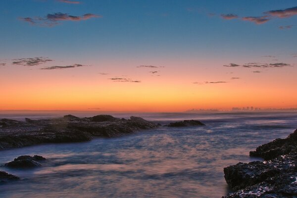 Rocky shore on the background of sunset