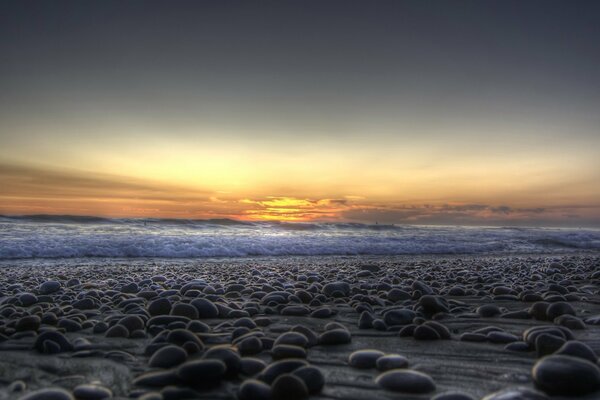 The stone shore in the rays of sunset