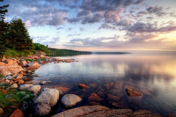 On the shore of the lake rocks and clouds