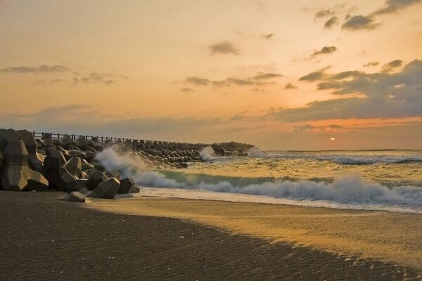 Sea waves at sunset on the pier