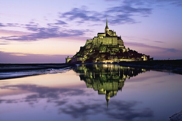 The castle on the mountain reflects the lights of the horizon