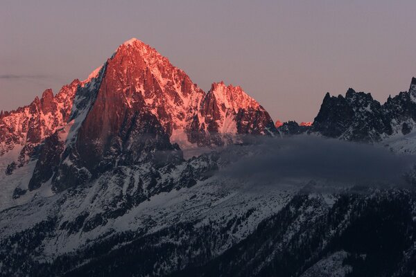 Dawn in the snowy mountains with clouds