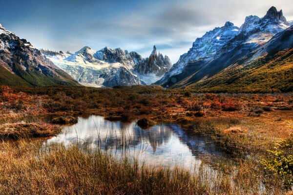 A pond surrounded by icy mountains