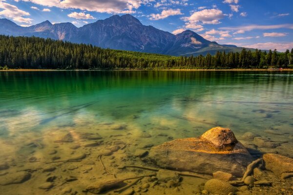 The lake is surrounded by forests and mountain peaks