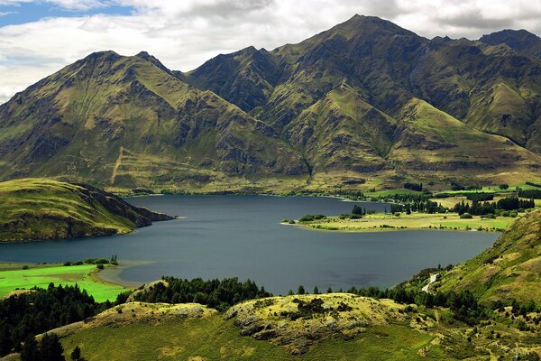 Paisaje del lago entre verdes picos de montaña y colinas